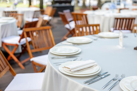 Beautifully organized event - round served table banquet ready for guests, round decorated table with empty plate, glasses, forks, napkin. Elegant dinner tableの写真素材
