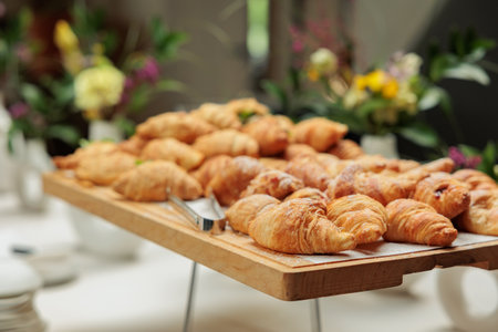 Fresh croissant a flaky, miniseries pastry on wooden board.