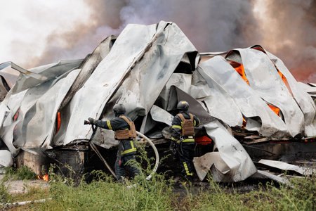 A firefighter puts out a burning warehouse. close up.