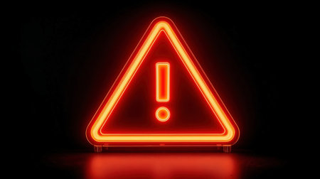 A glowing red neon triangle with an exclamation mark inside, set against a stark black background, symbolizing danger or warning.の素材