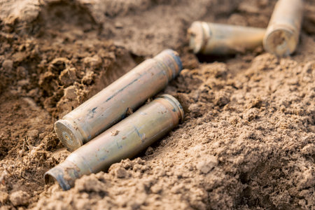 Empty carbine or rifle large-caliber cartridges close up. A large number of cases. Background of...