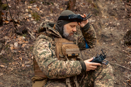 A Ukrainian soldier in camouflage with a drone control panel and satellite communications in a...