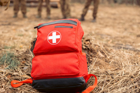 A red first aid kit with a white cross. It contains essential emergency supplies for outdoor...