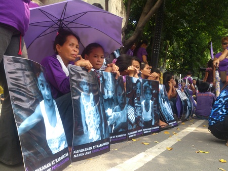 Protest during the oral debate of RH bill at the Supreme Court in Manila. A group of women in violet shirt brings their placard with validation that they are Catholics. のeditorial素材