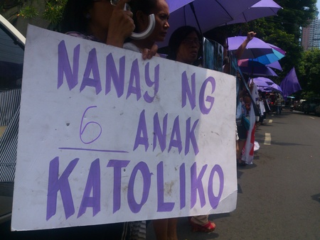 Protest during the oral debate of RH bill at the Supreme Court in Manila. A group of women in violet shirt brings their placard with validation that they are Catholics. Photo shows a woman with placard stating that she is a Catholic mother with six kids.のeditorial素材