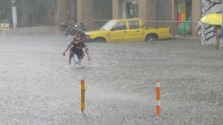 Flooding in Quezon City despite of drainage repair  A boy carrying his brother at the flooded Panay Avenue in Quezon Cityのeditorial素材