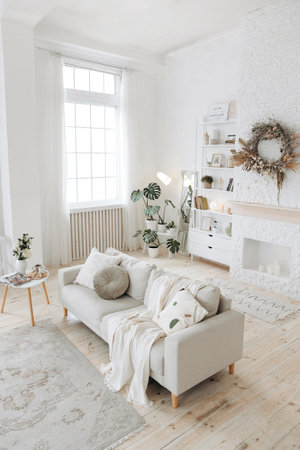 Modern stylish white living room with large windows and scandinavian style sofa against the backdrop...