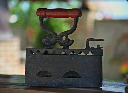 Old vintage iron standing on wooden shelfの写真素材