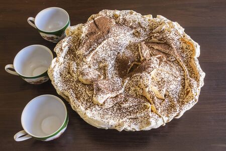 Meringue Cake with chocolate chips and three coffee cups. Still life. Polish cuisine.の写真素材