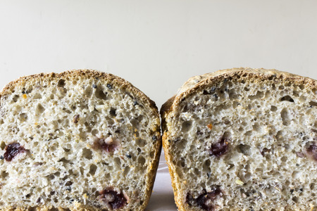 Two piece of homemade bread with cranberries. The Polish kitchen. Brown bread made from rye on a light background.の写真素材