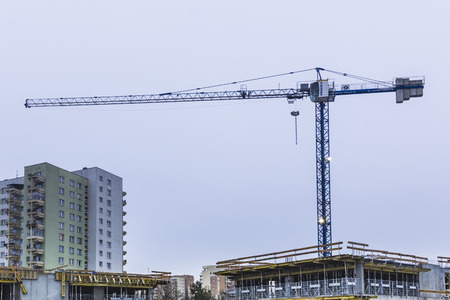 Unfinished residential building and two cranes. Concrete construction formwork. Construction site in the city of Warsaw, Poland.の写真素材