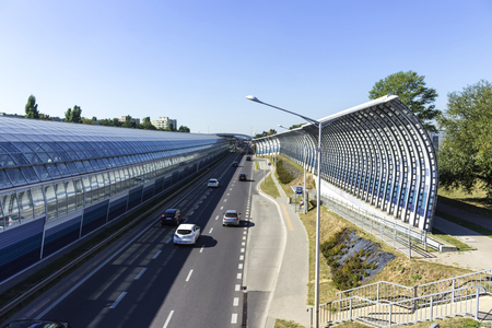 Bus stop near the sound-absorbing tunnel. Metal structure and screens, glass. Modern technology in the city of Warsaw, Poland.	の写真素材