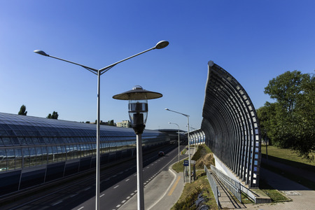 Lanterns near the bus stop and the sound-absorbing tunnel. Metal structure and screens, glass, light. Modern technology in the city of Warsaw, Poland.	の写真素材