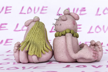 Toys "man" and "woman" from dough and salt. Valentine's day. Handmade. The word "Love" as a vertical background.の写真素材