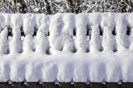 Bench in the park after a heavy snowfall.  Interesting photo for the site about nature, parks and seasons.の写真素材