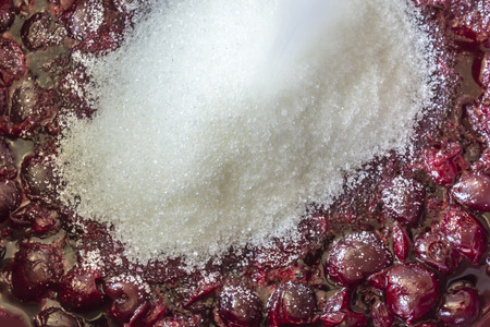 Cooking cherry jam . Hot dark red cherries and white sugar hill. Site about fruits, berries, food, cuisine and cooking. slideの写真素材