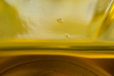 Macro photo. The bottom of the plastic bottle. The level of yellow vegetable oil.Site about the kitchen, photography, art, abstraction, food industry.の写真素材