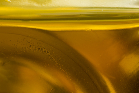 Macro photo. The bottom of the plastic bottle. The level of yellow vegetable oil.Site about the kitchen, photography, art, abstraction, food industry.の写真素材