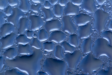 Macro photo. Abstract aqua pattern as background.. Violet  image. Drops of water on the glass.