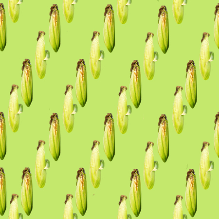 Raster oblique seamless pattern. Corn cobs on a green  background. Site about agriculture, farm, animal husbandry, graphics.の写真素材