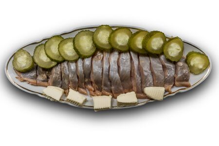 Sliced salmon fillet cut into pieces.Served with pickled cucumbers and butter.Isolated image.Lighting on the right.A site about fish,cuisine, cookery.の写真素材