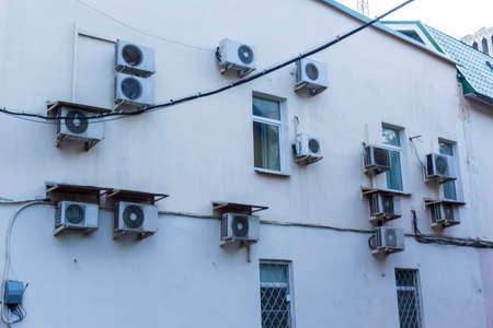 Air conditioners on the wall of the house in which the offices are located. Cases of external blocks of various shapes.の写真素材