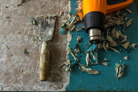Restoration of an old door. Removing old paint coats with a heat gun and a spatula. View from above....