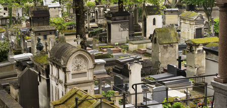 Old and ancient moss covered stone Crypts and Tombstones in a Graveyard in Europe