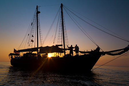 Gaff rigged schooner silouette in the setting sunの写真素材