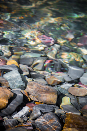 Closeup of rocks of different colors and sizes stacked along the riversideの写真素材
