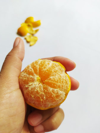 Holding peeled ripe yellow oranges isolated on white background
