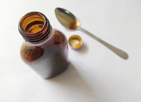 Cough syrup in a bottle that will be poured into a spoon