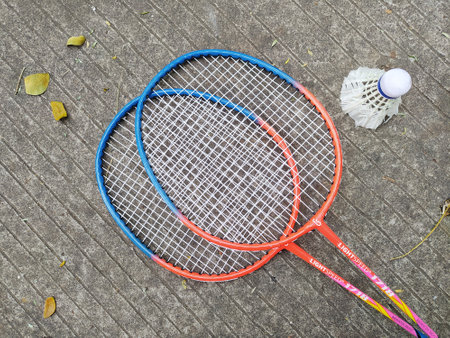 Shuttlecock and badminton racket on courtside background