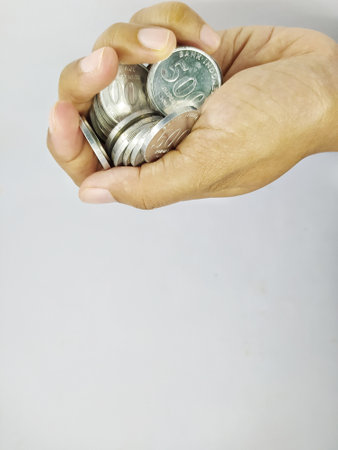 Holding some Indonesian rupiah coins, isolated on white backgroundの写真素材