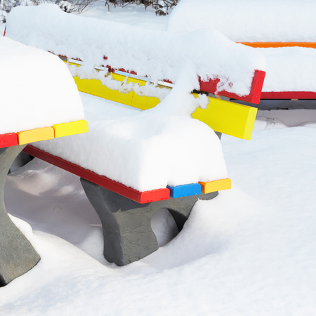 Colored outdoor benches in winter with a lot of snowの写真素材