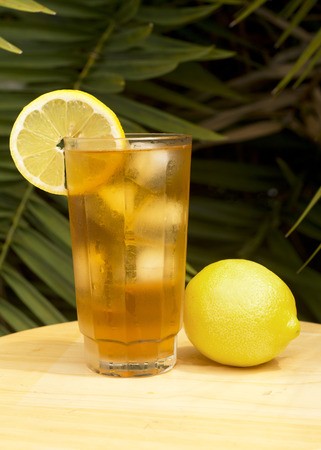 Iced tea in a glass with lemon outdoors.の写真素材