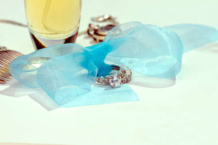 Wedding rings tied with a blue bow with perfume bottle and silver hair comb.の写真素材