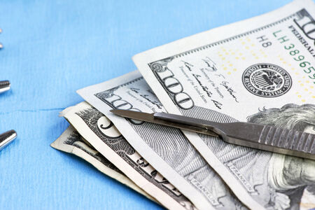 Stack of one hundred dollar bills on surgery table.  Concept photo.の写真素材