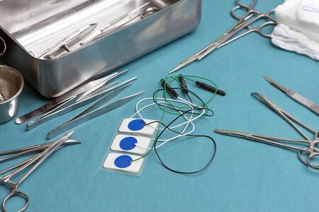 Electrocardiogram leads and surgical instruments on surgical table.
