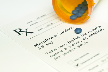 Morphine sulfate pills with bottle and prescription.