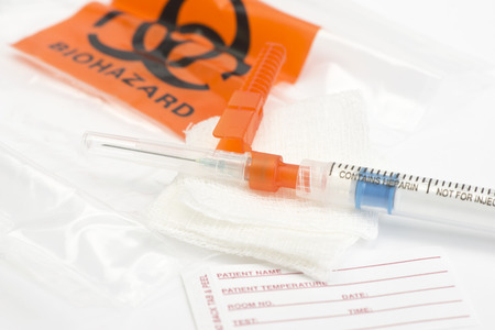 Arterial blood gas sample syringe with name tag and biohazard bag.  Heparin is a common non-trademarked medication name.の写真素材