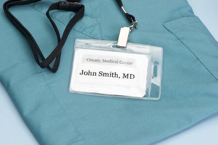 Obviously fictitious Doctor identification tag on scrubs with stethoscope.