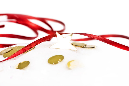 Gold star with red ribbon on snow close up.の写真素材