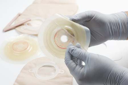 Nurse prepares ostomy supplies for use with patient.