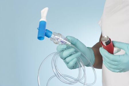 Nurse holding albuterol inhaler and breathing treatment mouthpiece.  Asthma treatment options.