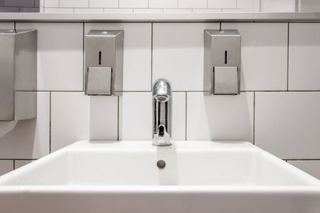 Cleaned, shiny toilet, bathroom close. White classic public toilet design. Crane with touch device...