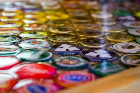 Minsk, Belarus - June 15, 2019: Original surface of the countertop is created from decorative elements and epoxy. Collection of beer caps with different brands of beer is collected at the bar.のeditorial素材