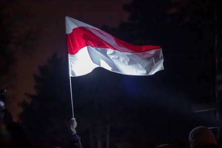 Blurred image of a man with the Belarusian flag in a raised hand.の写真素材