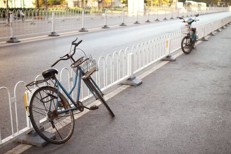 a bicycle lean on a fence in the streetの写真素材