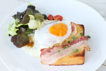 Plate of breakfast with fried egg, bacon, vegetables and toastの写真素材